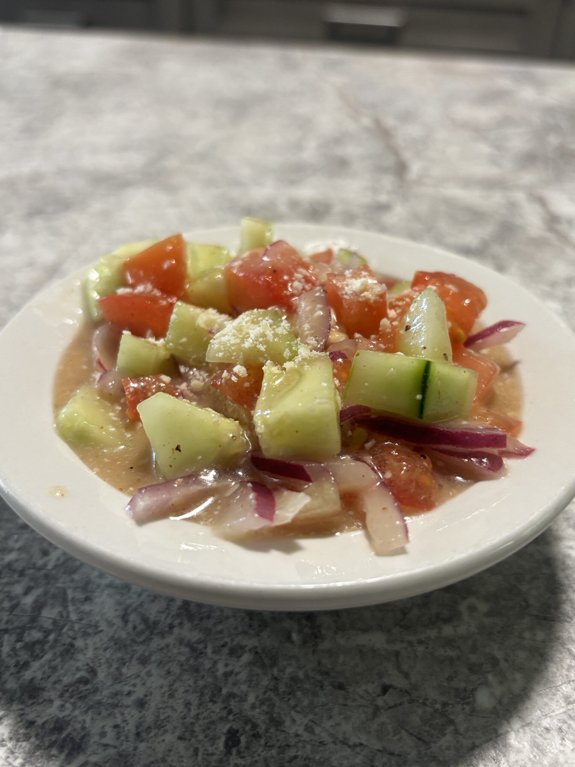 Crisp Apple Honey Cucumber Salad in a bowl, featuring cucumbers, tomatoes, onions, and a homemade apple honey vinaigrette.